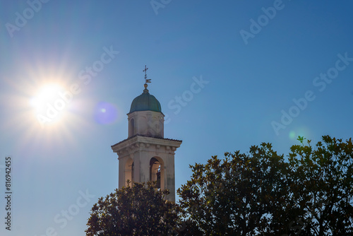 Church Tower of San Zenone Against Blue Clear Sky and Sunbeam in Campione d'Italia, Lombardy, Italy. photo