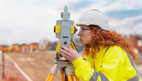 concentrate  female site engineer surveyor working with theodolite EDM equipment on building site
