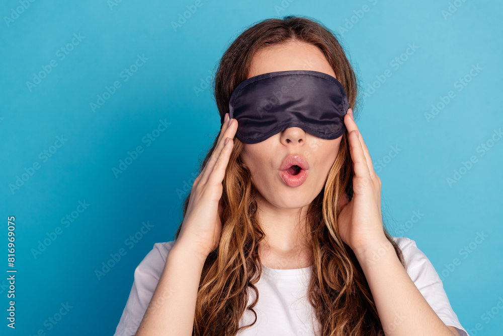 Photo of excited funny lovely girl wear white stylish nightwear hold mask isolated on blue color background Photo of excited funny lovely girl wear white stylish nightwear hold mask isolated on blue color background