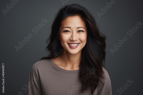 Wallpaper Mural Portrait of a grinning asian woman in her 30s smiling at the camera in front of soft gray background Torontodigital.ca