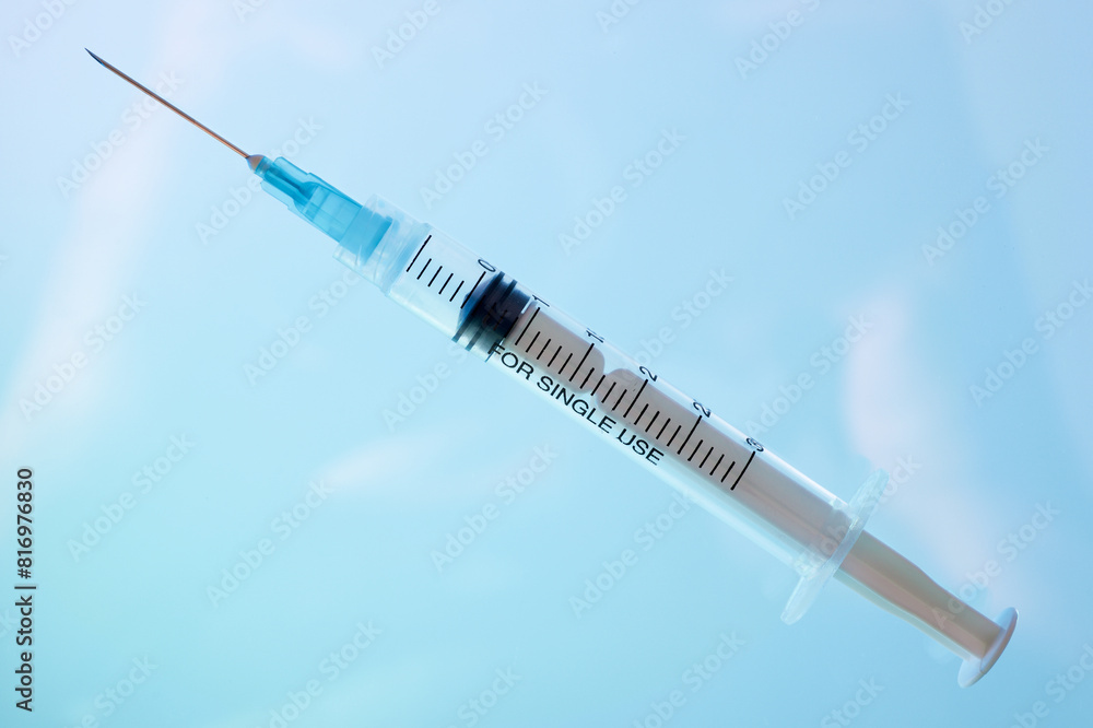 Hypodermic syringe on a blue background Hypodermic syringe on a blue background