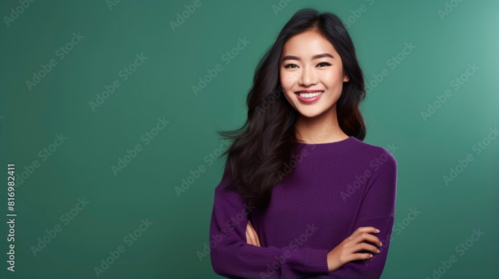 Fototapeta premium A young Asian woman with long black hair smiles at the camera. She is wearing a purple sweater.