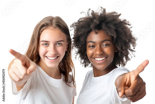 Two cheerful young multiethnic female friends pointing with index finger at camera. Isolated transparent background