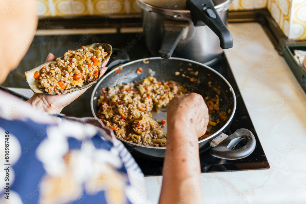 Elderly woman prepares meal in her kitchen Elderly woman prepares meal in her kitchen