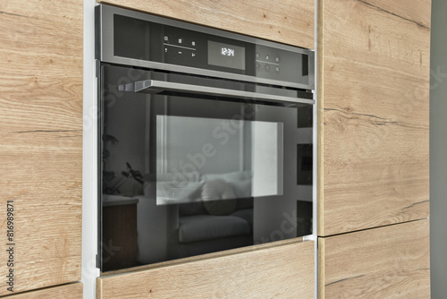 Modern built-in microwave oven integrated into wooden cabinetry photo