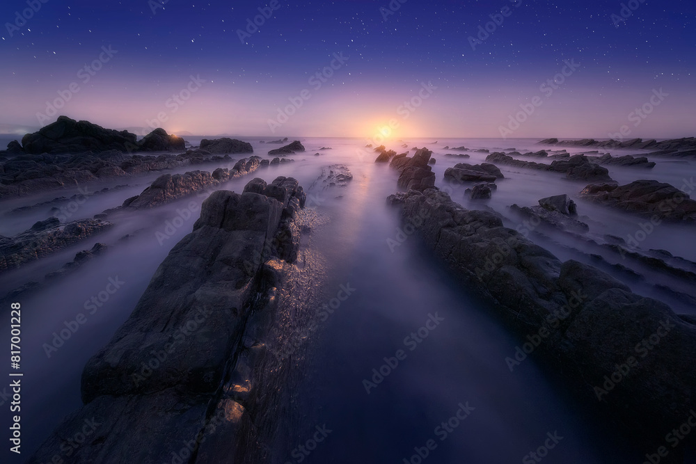 lunar sunset on Barrika beach, Bizkaia, with the sea water running between the flysch lunar sunset on Barrika beach, Bizkaia, with the sea water running between the flysch