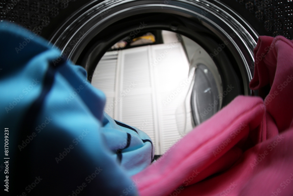 Clothes in washing machine indoors, view from inside. Laundry day Clothes in washing machine indoors, view from inside. Laundry day