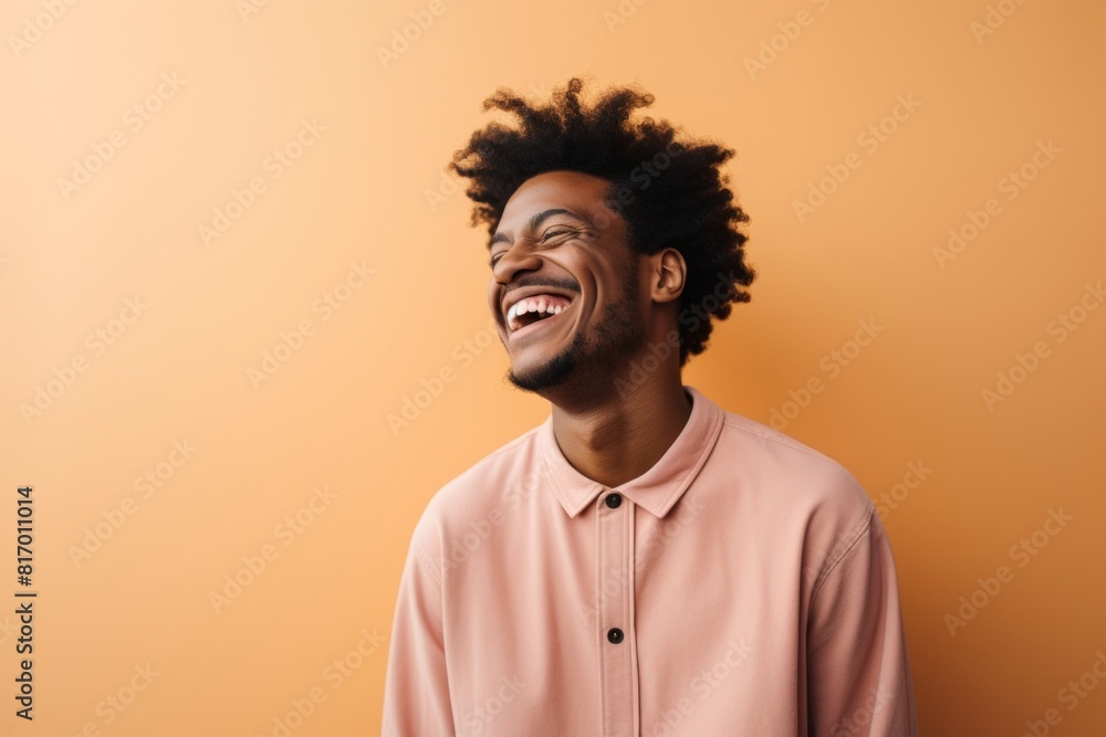Portrait of a content afro-american man in his 20s laughing isolated on pastel or soft colors background Portrait of a content afro-american man in his 20s laughing isolated on pastel or soft colors background