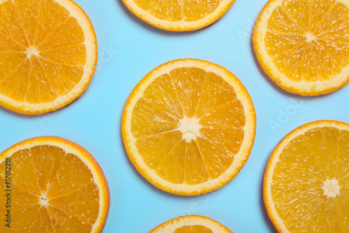 Slices of juicy orange on light blue background  flat lay