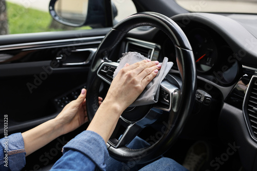 Woman wiping her modern car with rag, closeup