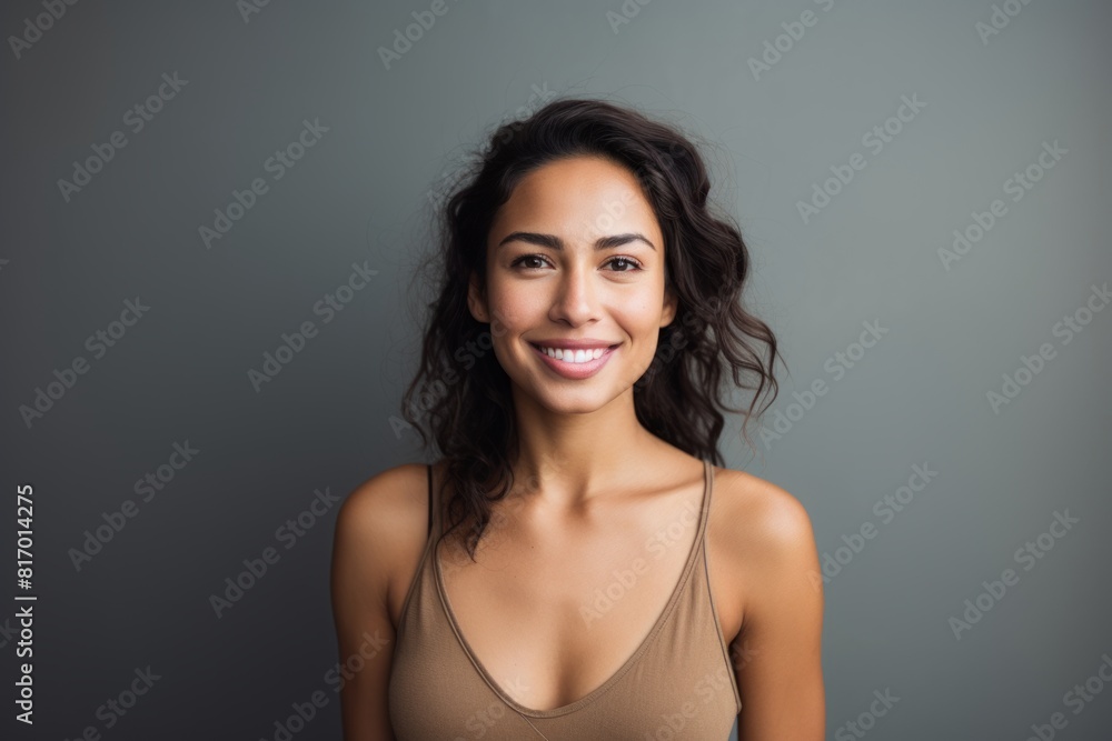 Portrait of a tender indian woman in her 30s smiling at the camera while standing against minimalist or empty room background Portrait of a tender indian woman in her 30s smiling at the camera while standing against minimalist or empty room background