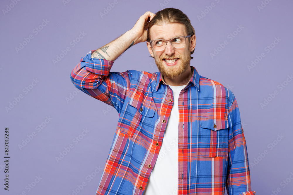 Young sad minded pensive puzzled confused man wear blue shirt casual clothes hold scratch head look aside on area isolated on plain pastel light purple background studio portrait. Lifestyle concept Young sad minded pensive puzzled confused man wear blue shirt casual clothes hold scratch head look aside on area isolated on plain pastel light purple background studio portrait. Lifestyle concept