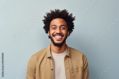 Portrait of a joyful afro-american man in his 30s smiling at the camera in minimalist or empty room background © Markus Schröder