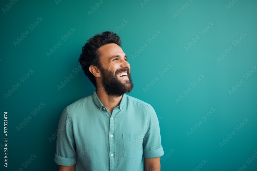 Fototapeta premium Portrait of a grinning man in his 30s laughing on minimalist or empty room background