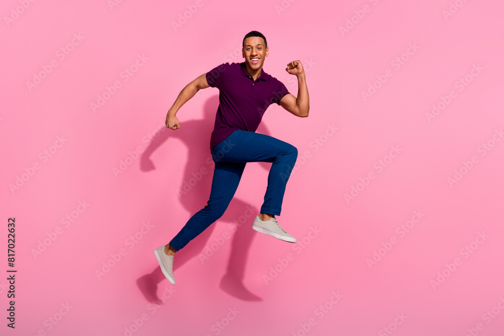 Full size photo of attractive young man running black friday dressed stylish violet clothes isolated on pink color background