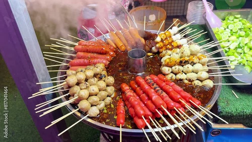 Assortment of Asian street food skewers simmering in hot, flavorful broth. Concept of diverse culinary experiences, street food culture and rich flavors of Asian cuisine