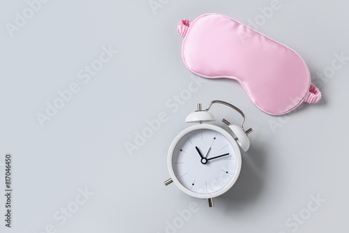 Obraz na płótnie Pink sleeping mask and watch, alarm on gray background. Concept of sleep, health care, daily routine and circadian rhythms. Copy space. w salonie