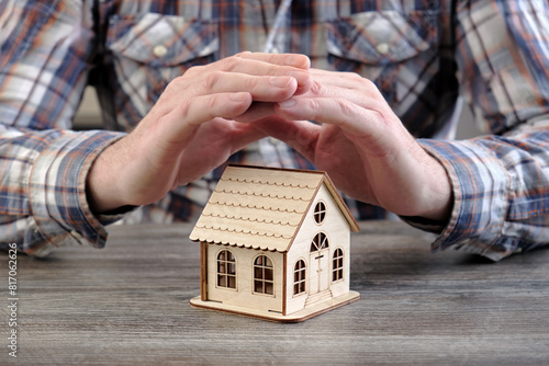 Εκτύπωση καμβά Close-up of a man holding his hands on top of a small wooden house