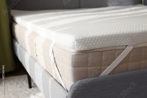 Fototapeta White memory foam mattress topper on grey bed indoors, closeup