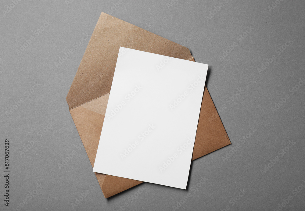Blank sheet of paper and letter envelope on grey background, top view Blank sheet of paper and letter envelope on grey background, top view
