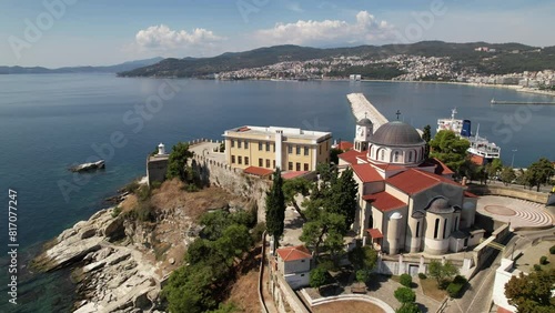 A breathtaking aerial view showcases a church precariously perched on a cliffs edge, offering stunning views of the vast sea below