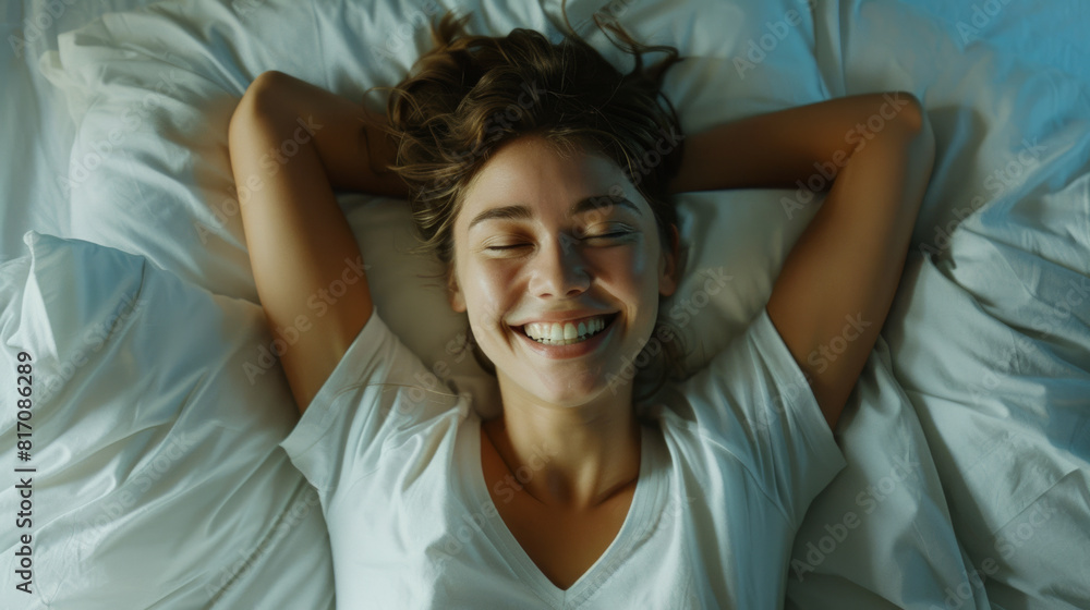 Peaceful Young woman lying in bed, smiling brightly, hands behind head.