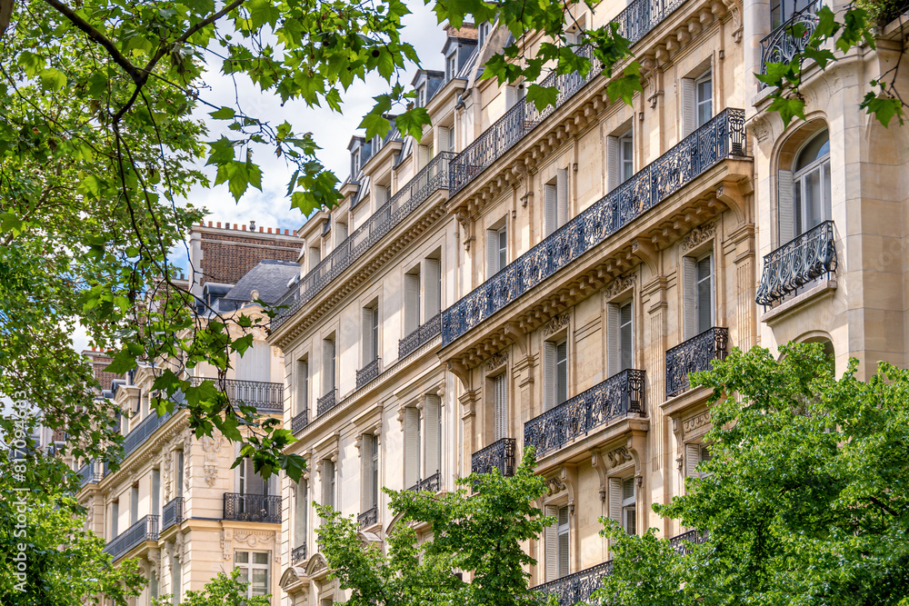 Façades d'immeubles résidentiels de style classique parisien le long d'une avenue bordée d'arbres. Concept de marché immobilier d'habitation pour les logements anciens en France et à Paris