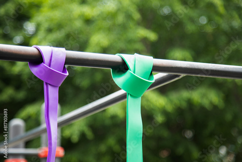 Obraz na płótnie Purple and green Elastic rubber bands for exercise tied on a horizontal bar . Horizontal shot . Close up view w salonie