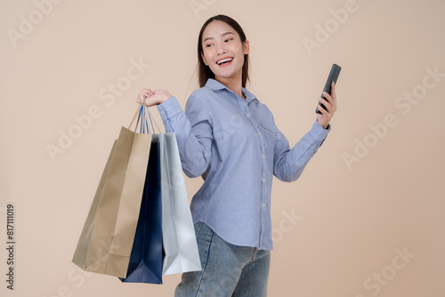 Joyful young woman with shopping bags and smartphone