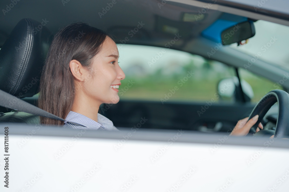 Smiling young woman sitting in the driver's seat, confidently holding the steering wheel of a car with a bright and cheerful expression, highlighting safe and enjoyable driving Smiling young woman sitting in the driver's seat, confidently holding the steering wheel of a car with a bright and cheerful expression, highlighting safe and enjoyable driving