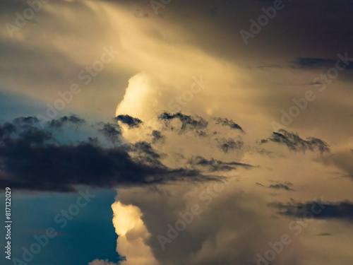 Foreground cloud and cloudlets in silhouette, with larger clouds in the distance illuminated by the sun, on a summer evening in southwest Florida, for motifs of difference and transition photo