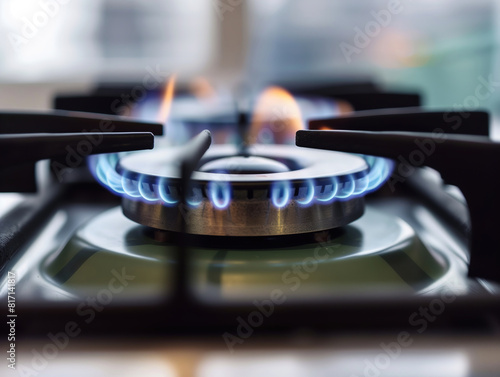 A gas stove burner with a vibrant blue flame.