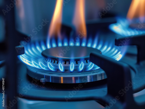 A gas stove burner with a vibrant blue flame.