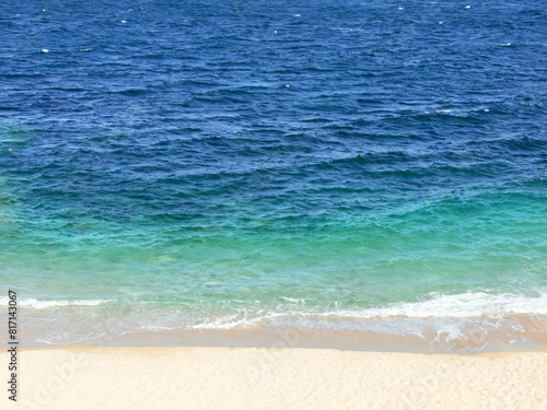 Blue and bright turquoise sea and sandy beach horizontal background.