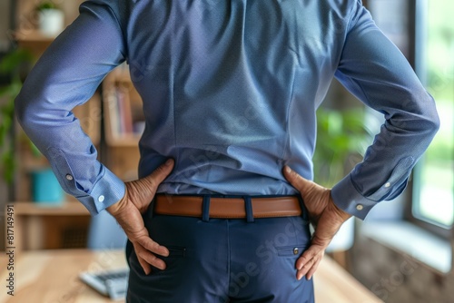 Man Holding Lower Back in Pain at Office