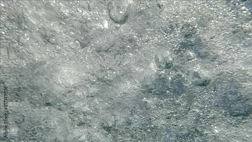 The seething surface of the water from raindrops falling on it during a heavy downpour, view from under water, slow motion, natural background photo