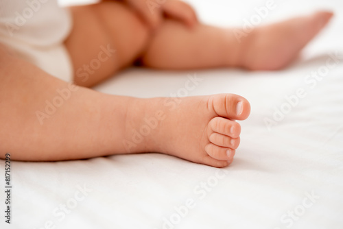 the legs of a small child on a white background on the bed, a pl