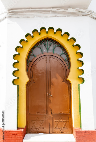Arabian style entrance gate with a brown wooden closed door