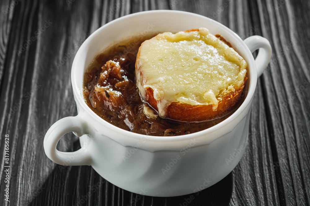 delicious original french onion soup on a black rustic wooden background delicious original french onion soup on a black rustic wooden background