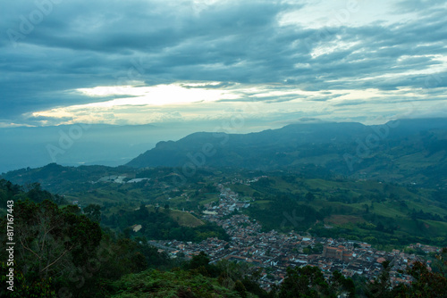 Wide panorama of the colonial village  pueblo  of Jerico  Jeric    Antioquia  Colombia  with an evening orange sky and the Andes Mountains in the background. From the Cerro las Nubes.