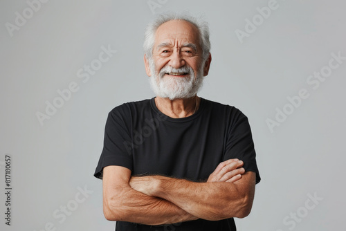 An elderly man with a full white beard is striking a pose for a photograph, showcasing his distinguished appearance