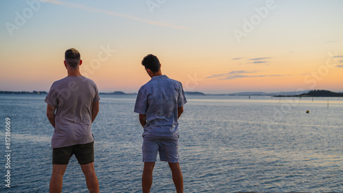 Foto two friends looking at the sea horizon while pissing
