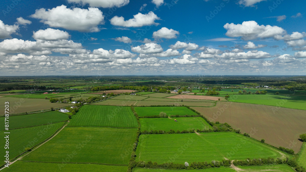 Naklejka premium Drone footage view of the meadows in Ireland with beautiful blue sky and clouds