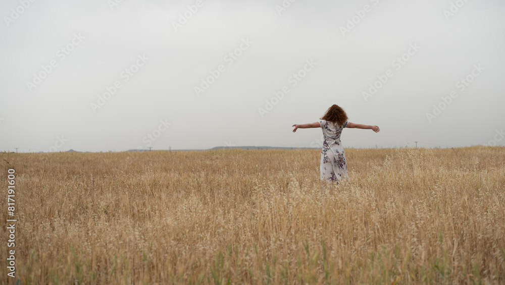 Carefree woman with stretched hands feels happy and healthy outdoor in wheat field. Carefree woman with stretched hands feels happy and healthy outdoor in wheat field.