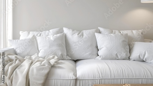 a Scandinavian-style interior mockup featuring a pristine white linen sofa adorned with plain cotton pillows, alongside a light wood end table.