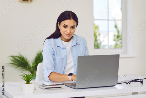 Fotografie Woman manages tasks at desk at home or office