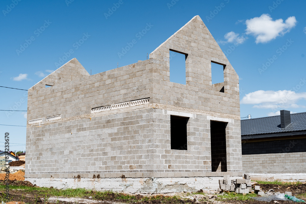 Brick house being built under blue sky with sunny landscape