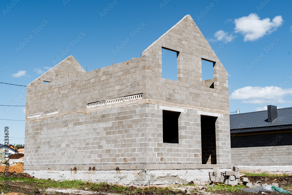 Brick house being built under blue sky with sunny landscape Brick house being built under blue sky with sunny landscape