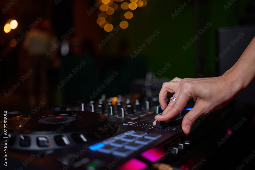 Fototapeta premium control DJ for mixing music with blurred people dancing at party in nightclub.