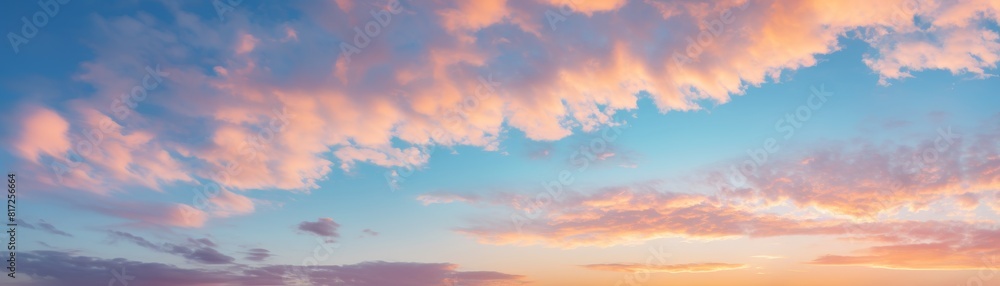 A dramatic cloudscape at sunrise with pink and golden glowing clouds against a clear blue sky A dramatic cloudscape at sunrise with pink and golden glowing clouds against a clear blue sky